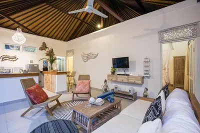 a living room with a couch and a table at Villa Kamboja Younger in Seminyak