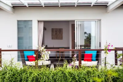 a balcony with colorful chairs on a house at Sunset Paradise Villa Jimbaran 8008 in Jimbaran