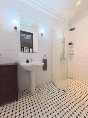 a bathroom with a sink and a glass shower at Villa Antiga 2 in Seminyak