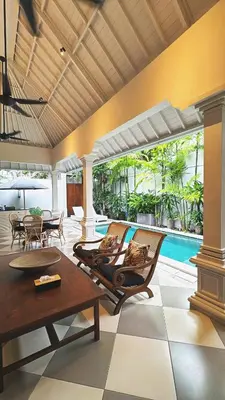 a living room with two chairs and a pool at Villa Antiga 2 in Seminyak