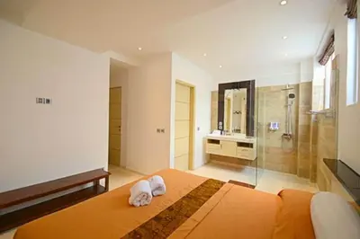 a bedroom with a large bed and a shower at Flora Apartment Bali in Seminyak