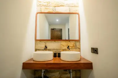 a bathroom with two sinks and a mirror at Palm Garden Kuta in Kuta