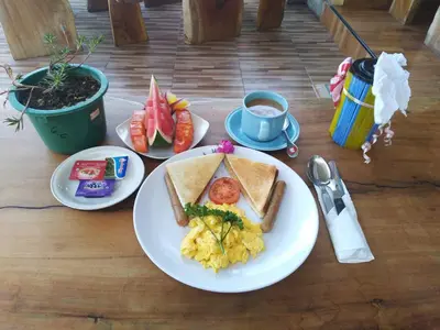 a table with a plate of food with eggs and toast at Beji Ayu Homestay in Seminyak