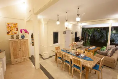 a kitchen and living room with a table and chairs at Villa Alam Biru Gardenia in Seminyak