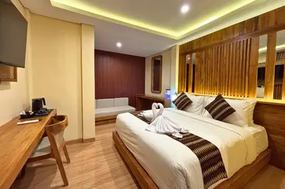 a hotel room with a large bed and a desk at AB Hotel Kuta in Kuta