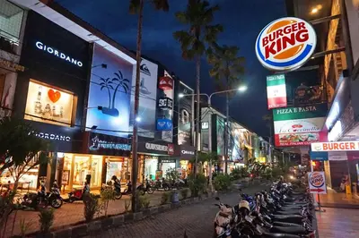 a group of motorcycles parked on a city street at night at AB Hotel Kuta in Kuta