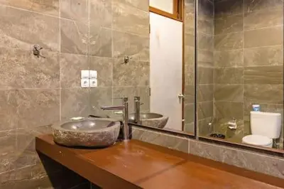a bathroom with a sink and a mirror at Villa Tiah in Kuta