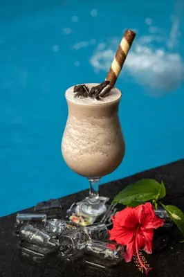 a drink with a cinnamon stick in a glass at Legian Village Beach Resort - CHSE Certified in Legian
