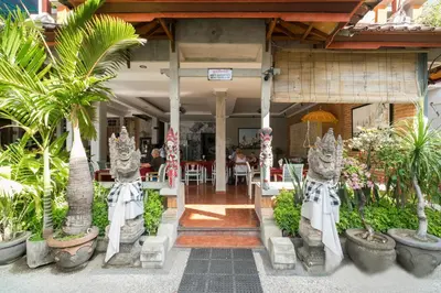 a restaurant with palm trees and plants in front of it at Legian Village Beach Resort - CHSE Certified in Legian