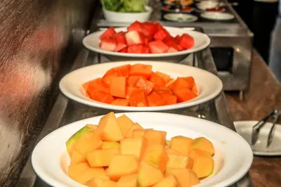 three plates of fruit on a buffet table at The Crystal Luxury Bay Resort Nusa Dua in Nusa Dua