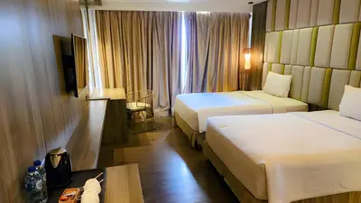 a hotel room with two beds and a table at The Crystal Luxury Bay Resort Nusa Dua in Nusa Dua