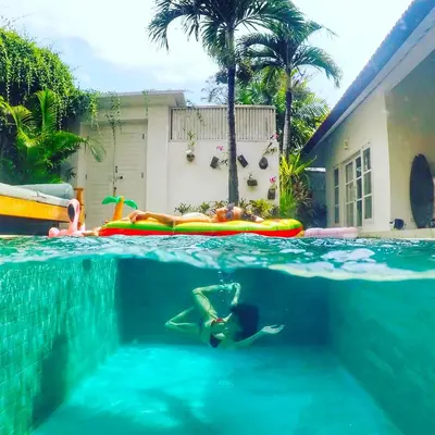 a person swimming in a swimming pool in a swimming pool at Villa Niluh in Canggu