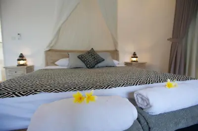 a bedroom with a bed with towels with flowers on them at Villa Niluh in Canggu