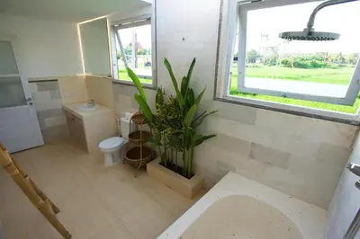 a bathroom with a toilet and a plant in it at Villa Niluh in Canggu