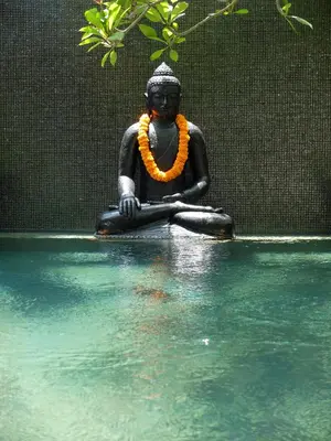 a statue of a woman sitting in the water at Amanputri Villa in Seminyak