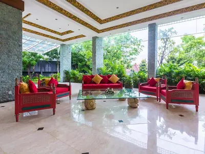 a living room with red couches and a glass table at The Sintesa Residence Jimbaran in Jimbaran