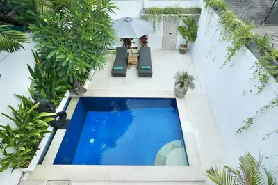 an overhead view of a swimming pool with chairs and an umbrella at Villa Lamac in Legian