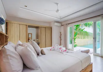 a bedroom with a large white bed with pillows at Bali Villa Beachfront Luxe Rooftop Sunsets in Canggu