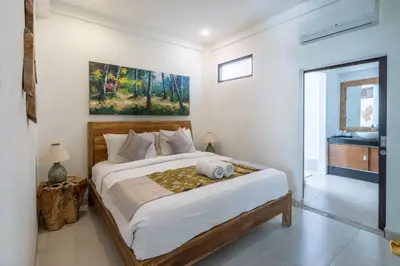 a bedroom with a large bed and a bathroom at Villa Aveli Seminyak by Best Deals Asia Hospitality in Seminyak