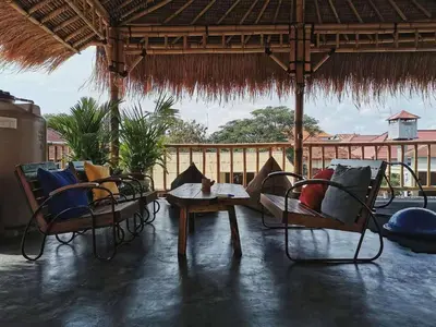 a pavilion with chairs and a table and a table and chairs at Nuka Beach Inn in Kuta