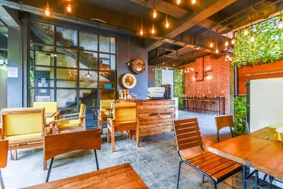 a dining room with wooden tables and chairs at The Aswana Seminyak in Seminyak