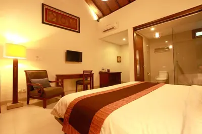a bedroom with a bed and a desk and a chair at Adys Inn in Legian