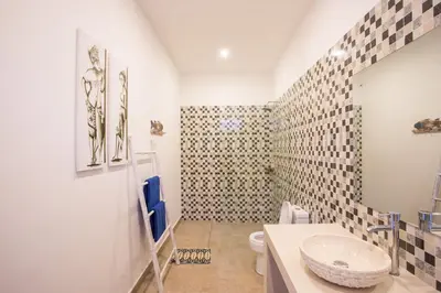 a bathroom with a toilet and a sink at Holyfat Villa in Seminyak