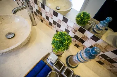a bathroom counter with a sink with two plants on it at Holyfat Villa in Seminyak