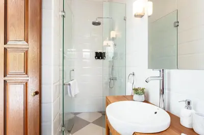 a bathroom with a glass shower and a white sink at Villa Wahah in Seminyak