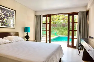 a bedroom with a bed and a swimming pool at Villa EMMA | heart of Seminyak | 350m Beach in Seminyak