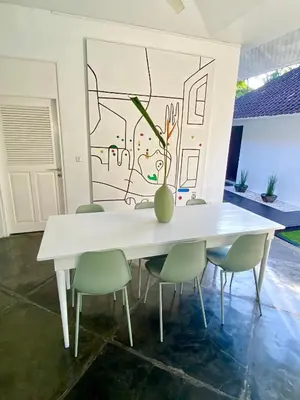 a white table with chairs and a vase on it at Villa EMMA | heart of Seminyak | 350m Beach in Seminyak