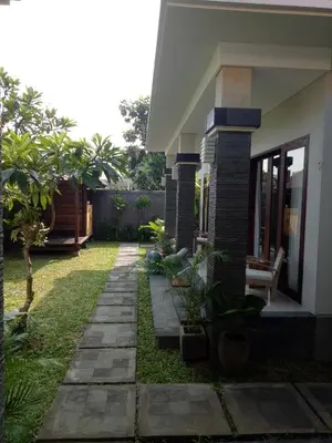a garden outside a house with a pathway at Guest House Reisya in Nusa Dua