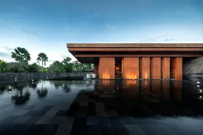 a building with a reflection in the water at Hotel Indigo Bali Seminyak Beach by IHG in Seminyak