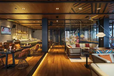 a restaurant with tables and chairs and a bar at Hotel Indigo Bali Seminyak Beach by IHG in Seminyak