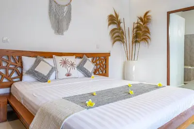 a bedroom with a bed with flowers on it at Villa Mangga 3 chambres seminiak in Seminyak