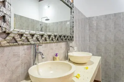 a bathroom with two sinks and a mirror at Villa Mangga 3 chambres seminiak in Seminyak