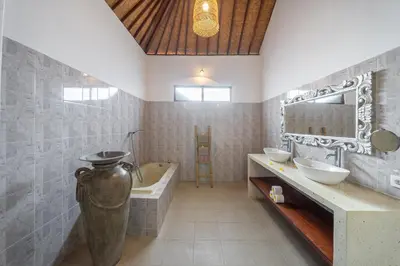 a bathroom with a bath tub and a large vase at Villa Mangga 3 chambres seminiak in Seminyak