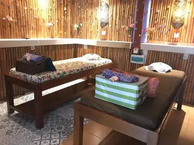 a room with two beds and a table with twounks at Seahouse Bali Indah Beach Inn in Kuta