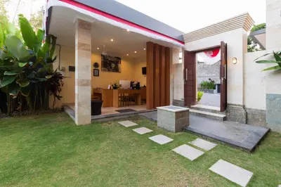 a house with a green lawn in the yard at Kubu Petitenget Suite Seminyak in Seminyak