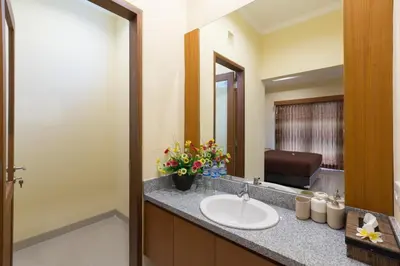 a bathroom with a sink and a mirror at Kubu Petitenget Suite Seminyak in Seminyak