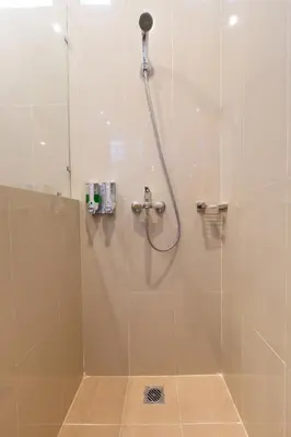 a bathroom with a shower with a glass door at Kubu Petitenget Suite Seminyak in Seminyak