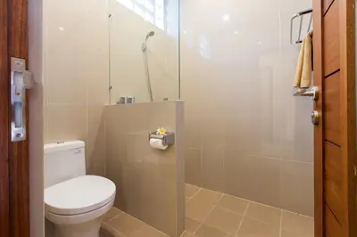 a bathroom with a toilet and a shower at Kubu Petitenget Suite Seminyak in Seminyak