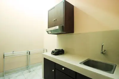 a kitchen with a sink and a camera on the counter at Dee Mansion Bali in Denpasar