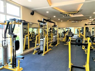 a gym with yellow tread machines in a room at Dee Mansion Bali in Denpasar