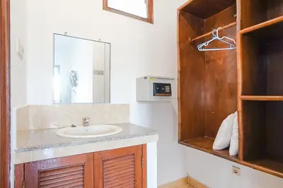 a bathroom with a sink and a mirror at Indopurejoy House - Komala Indah Cottages in Kuta