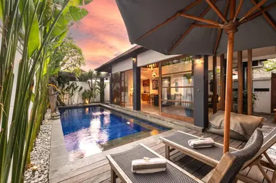 a villa with a swimming pool and an umbrella at Villa Dee 6 in Seminyak