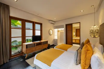 a bedroom with a bed and a desk and a television at Villa Dee 6 in Seminyak