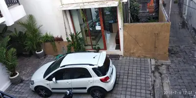 a white car parked in front of a building at D'Pande Kuta in Kuta