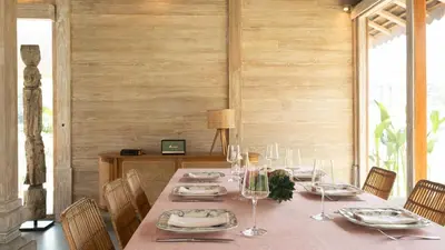 a dining room with a table with plates and wine glasses at Villa Du Ho by Villa Finder in Kerobokan