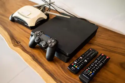 a table with two remote controls and a game controller at Villa Rani 3 in Seminyak